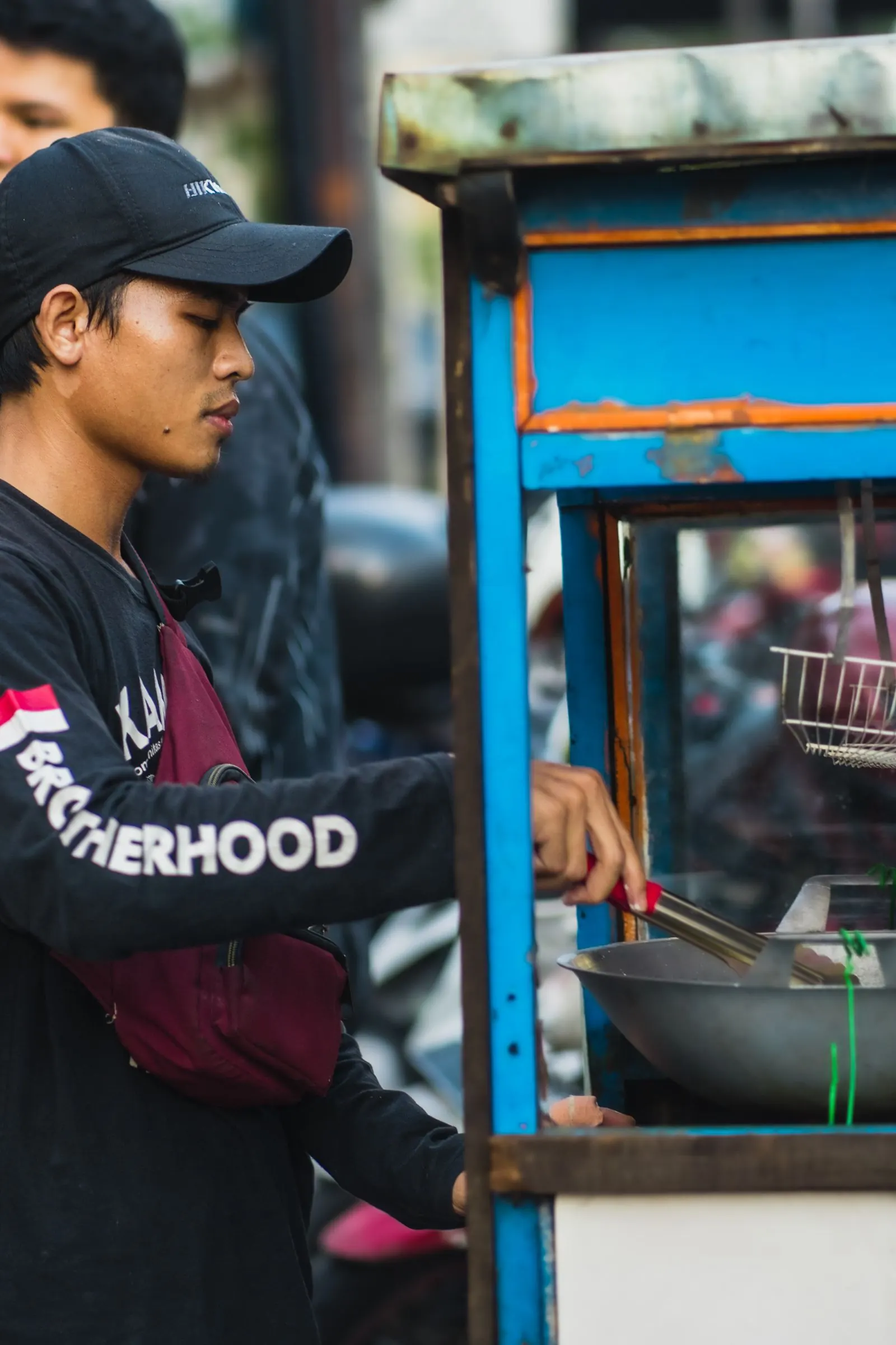 Penjual menyiapkan pesanan di kios makanan di Indonesia